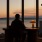 man sitting and looking out window at dusk